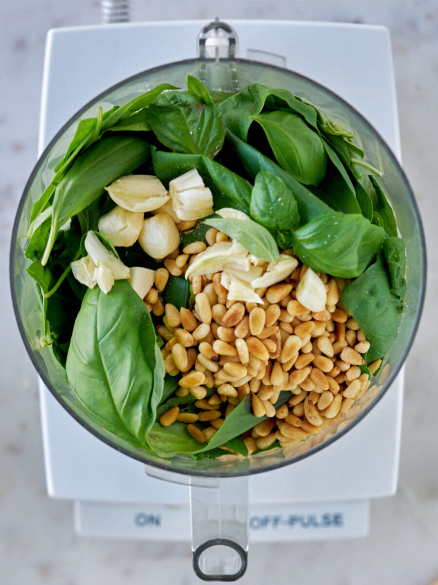 Food processor with ingredients for pesto.