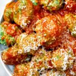 Spinach dumplings with red sauce and parmesan.