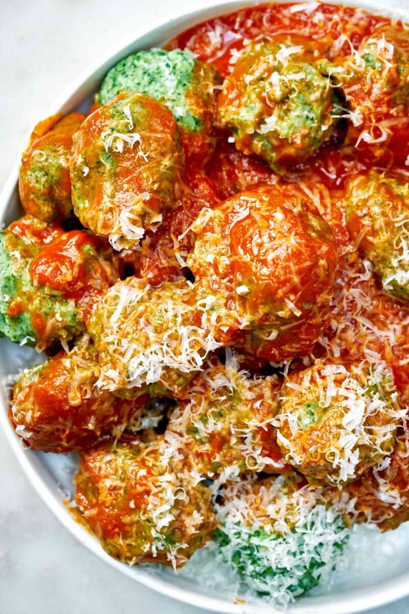 Spinach dumplings with red sauce and parmesan.