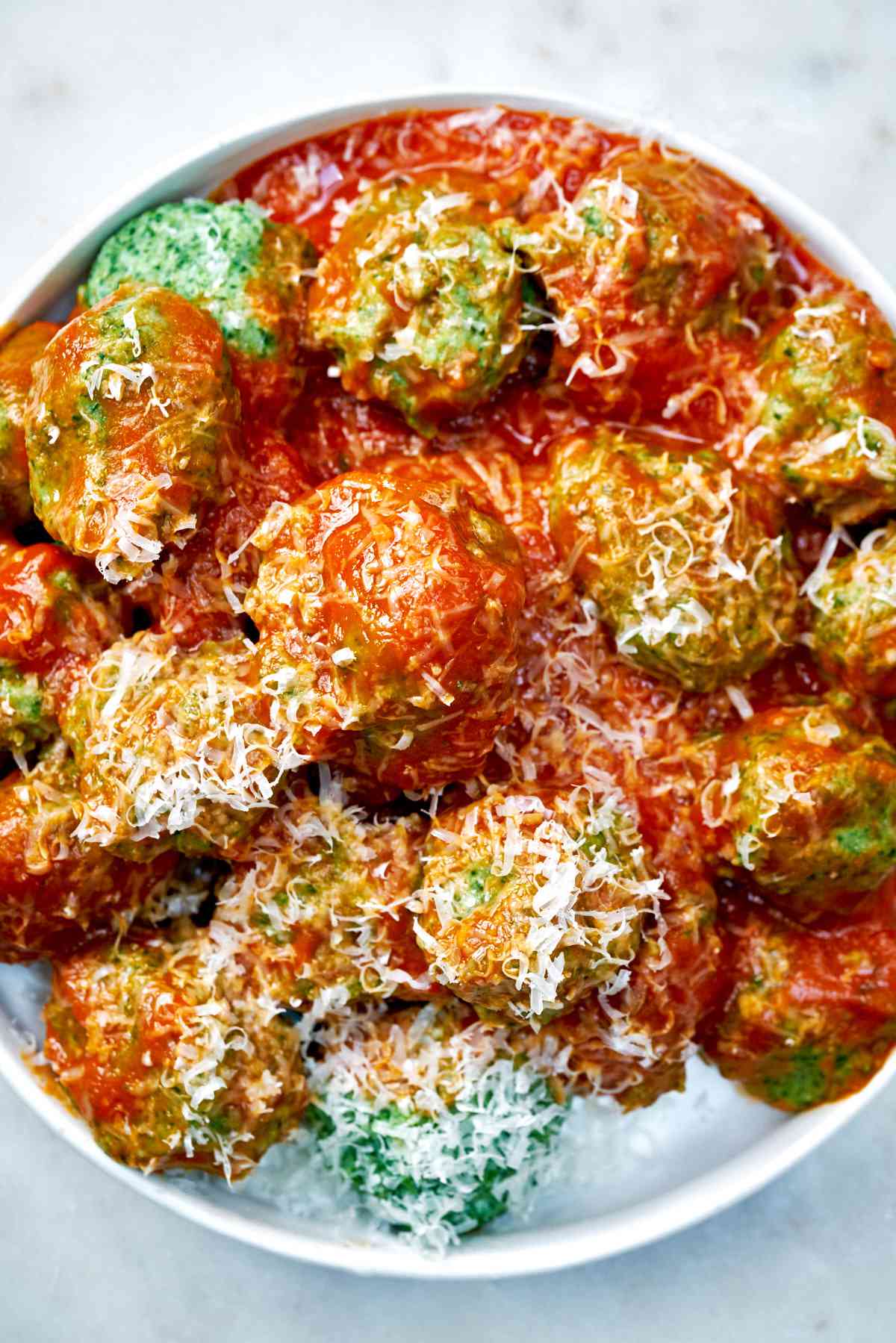 Spinach dumplings with red sauce and parmesan.