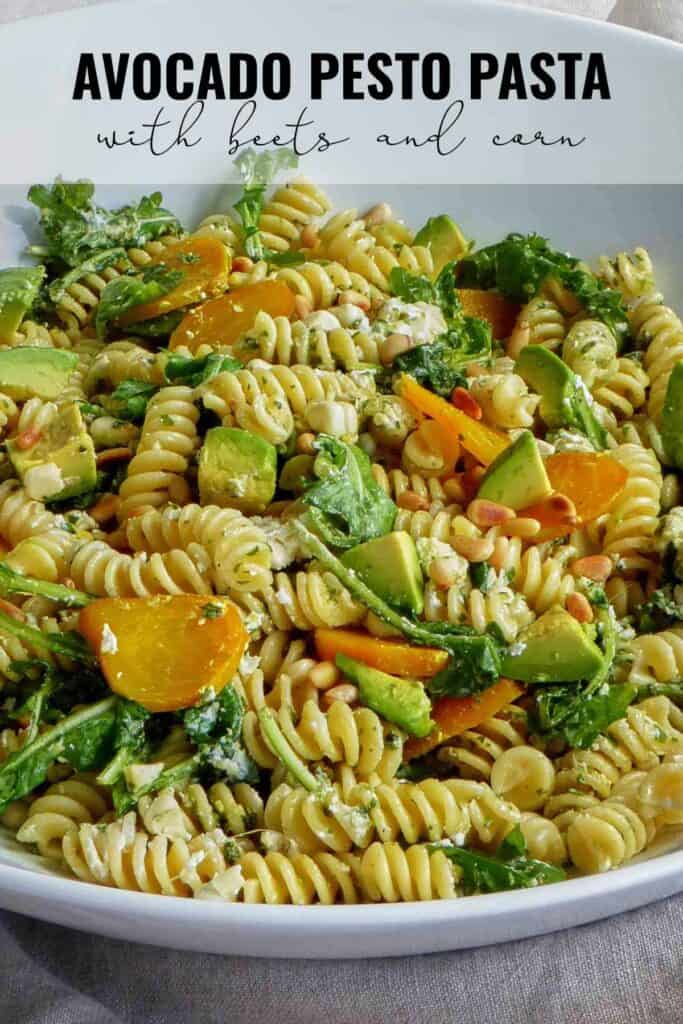 Close up of a serving bowl filled with pasta, avocado, cheese, and golden beets with title text.