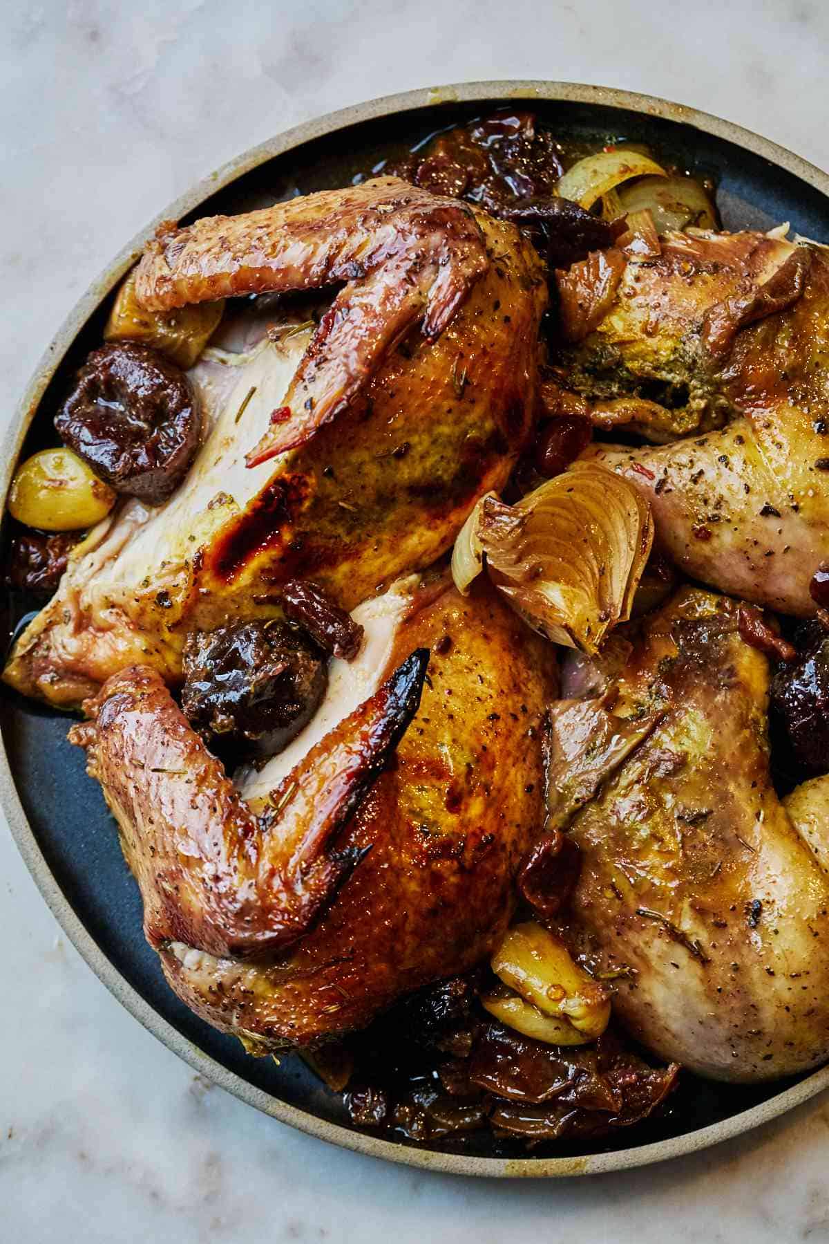 Sliced whole chicken on a black plate.