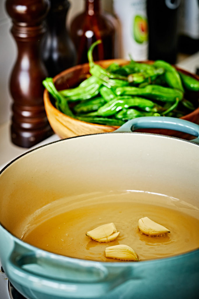 Three cloves of garlic cooking in oil.