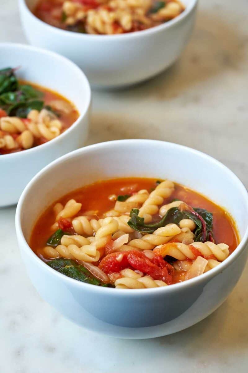 Bowl of red soup with noodles.