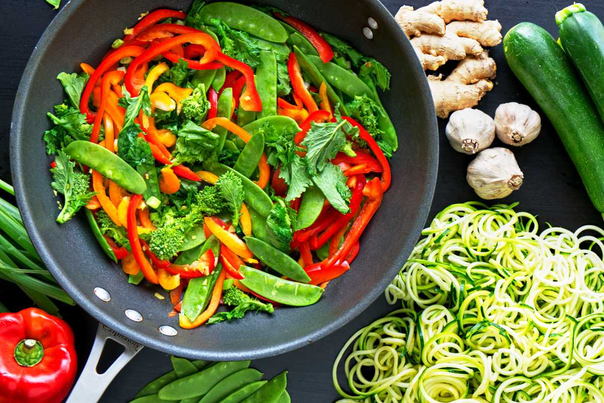 Colorful stir fry next to zoodles.