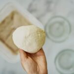 Ball of dough in a hand.
