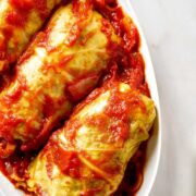 Three cabbage rolls on an oval plate.