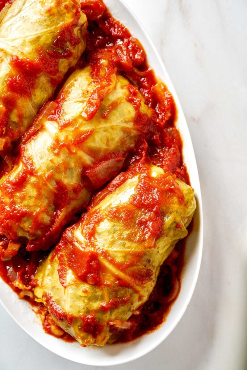 Three cabbage rolls on an oval plate.