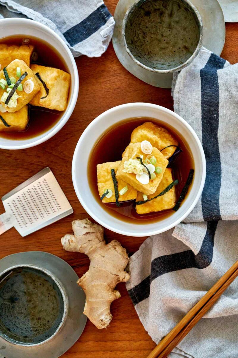 Agedashi tofu in a bowl with brown dashi liquid.