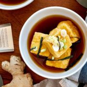 Agedashi tofu in a bowl with brown dashi liquid.