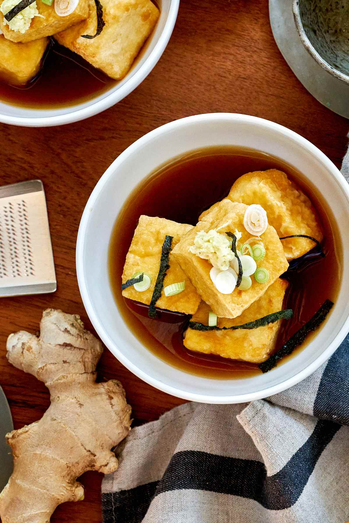 Agedashi tofu in a bowl with brown dashi liquid.