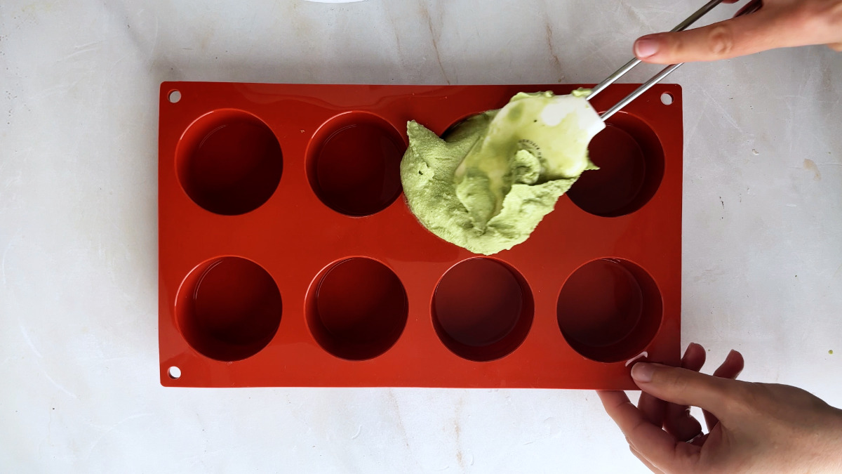 Adding ice cream to a red mold tray.
