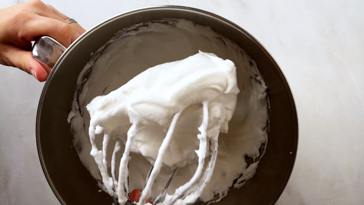 Whipped egg whites on a stand mixer whisk.