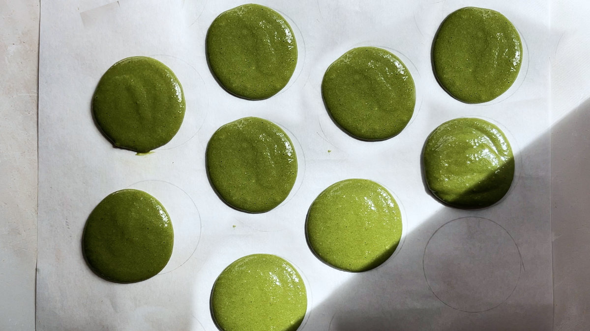 Unbaked macarons on a baking sheet.