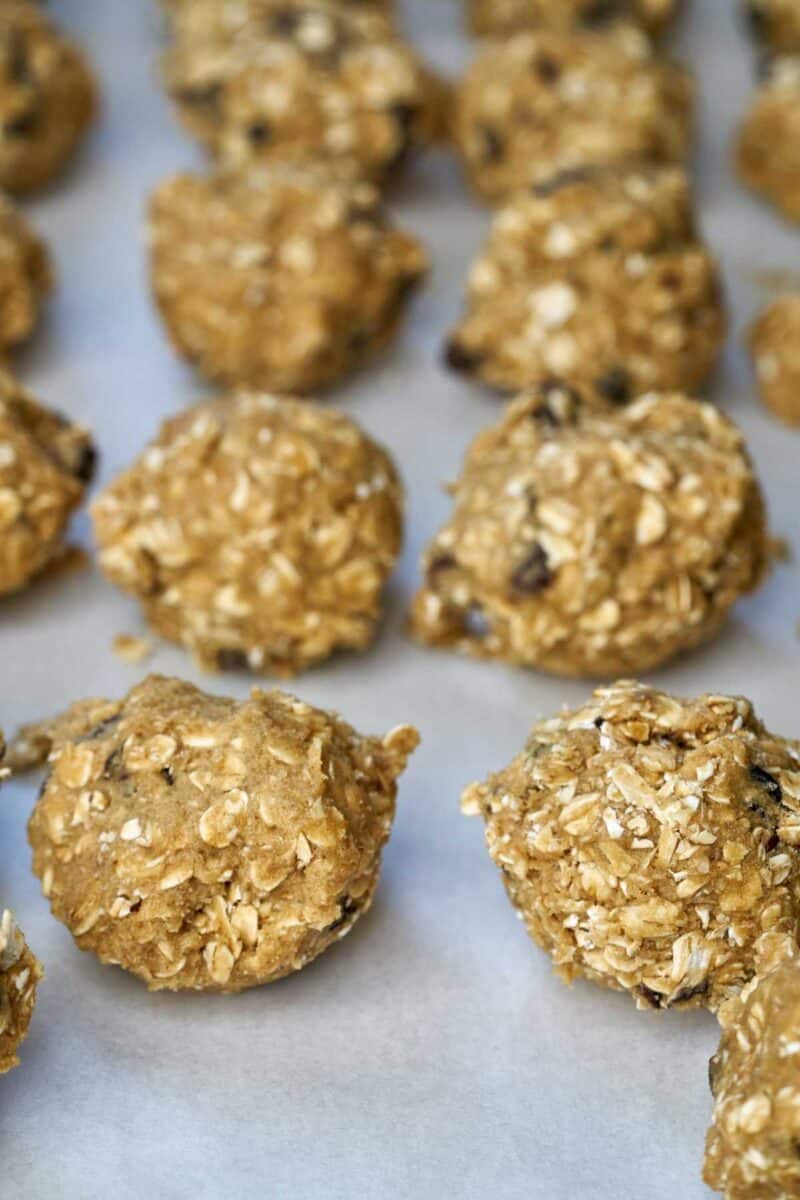 Cookie dough scoops on parchment paper.