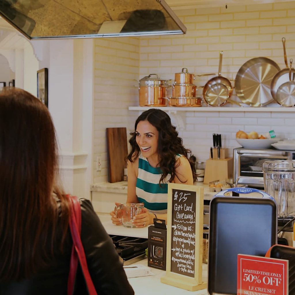 Smiling woman cooking in an in-store kitchen.