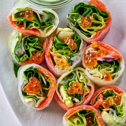 Small cut pieces of salad rolls next to dipping sauce.