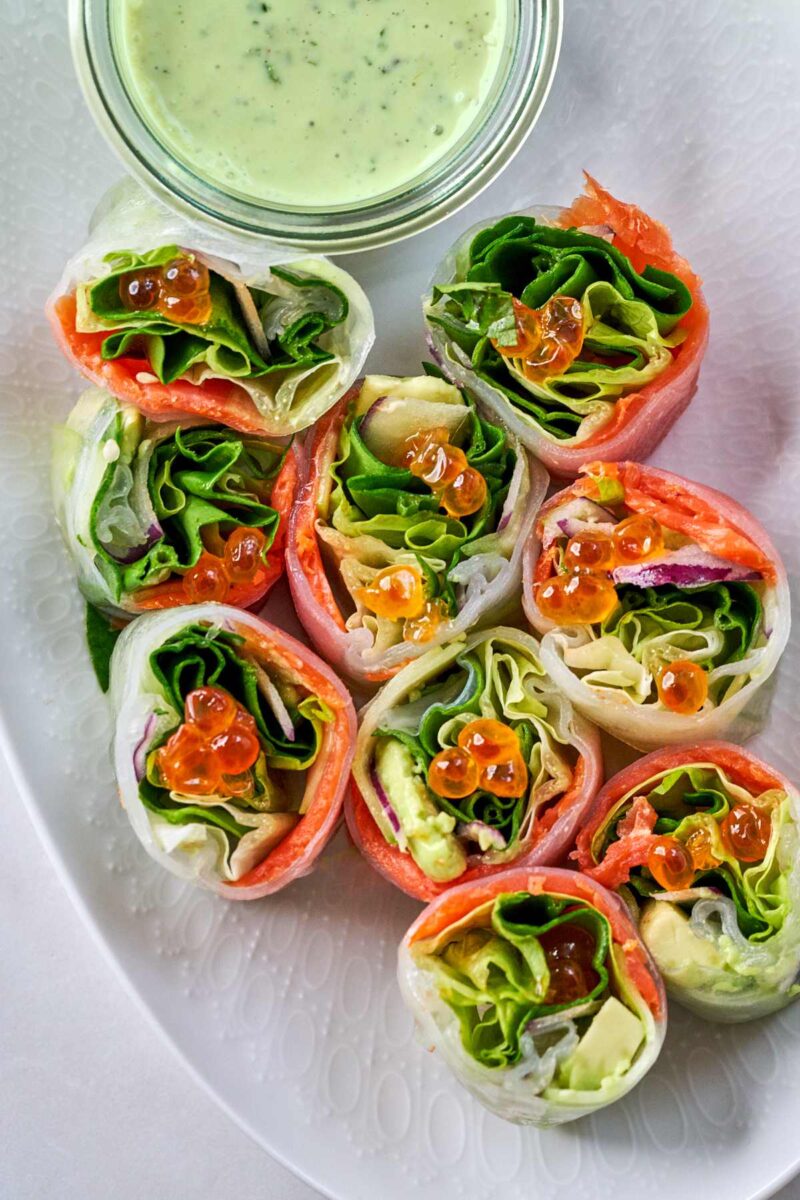 Small cut pieces of salad rolls next to dipping sauce.