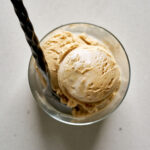 Ice cream in a glass cup with a spoon.