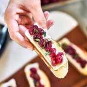 Hand holding a piece of crostini.