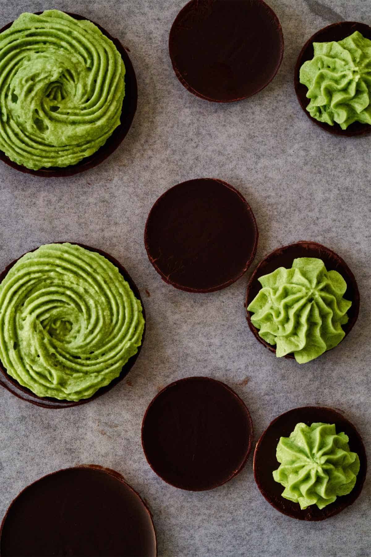 Chocolate discs topped with green piping.