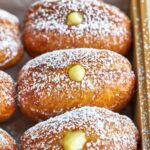 Filled donuts in a wood box.