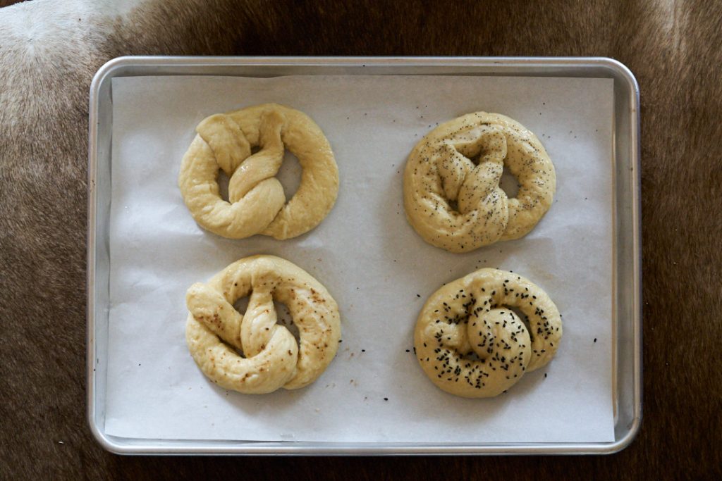 Boiled pretzels on a baking sheet.