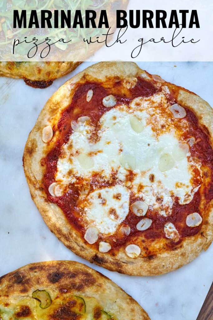 Pizza with red sauce and garlic on white marble with title text.