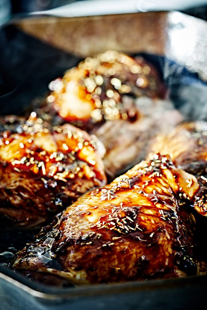 Chicken thighs cooking in cast iron pan.