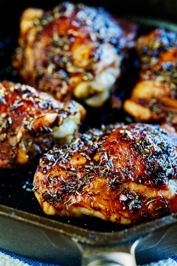 Close up of roasted chicken thighs in a cast iron pan.