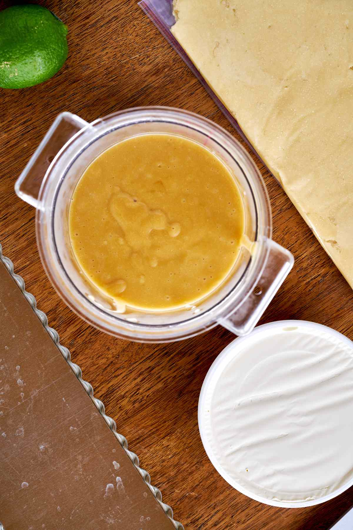 Lime curd in a plastic container next to mascarpone cheese.