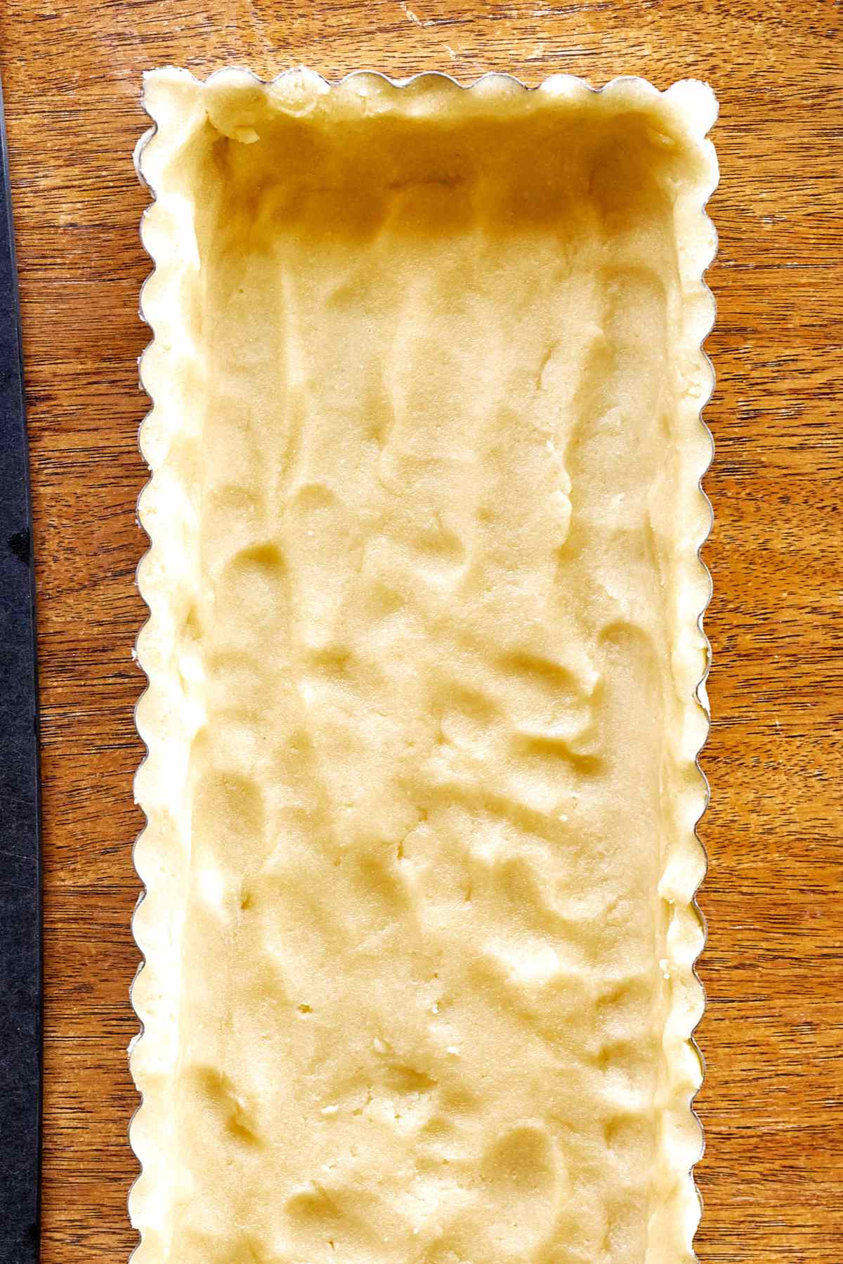 Dough pressed into a tart pan.