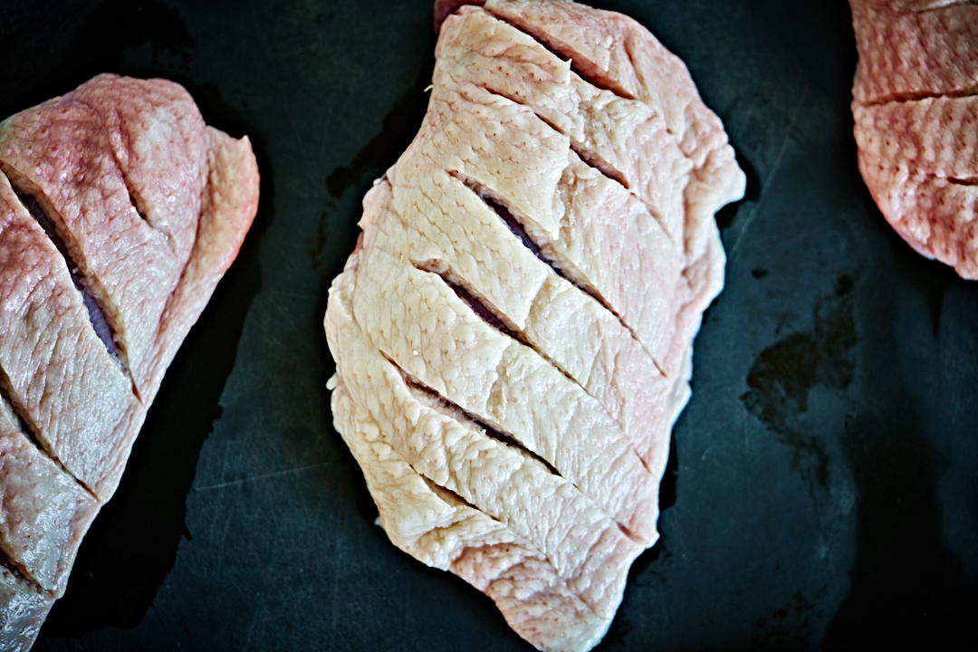 Duck breasts with scored skin.