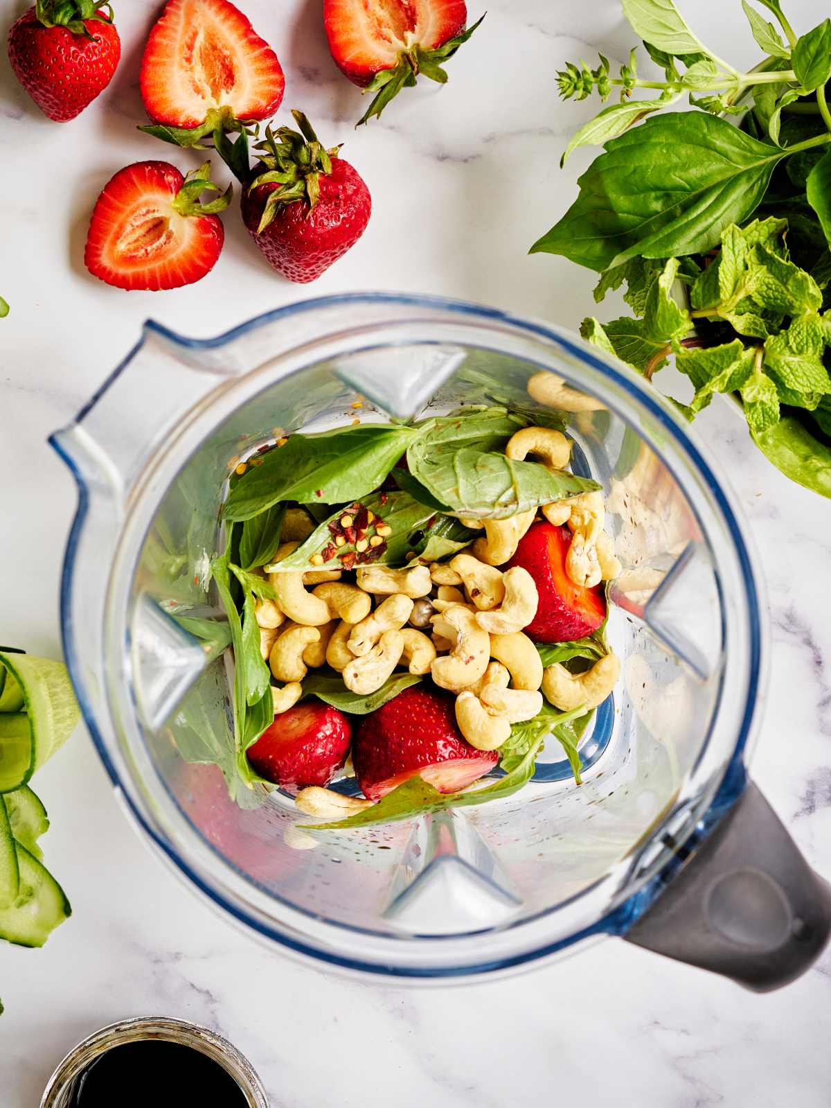 Cashews, strawberries, and other ingredients to make a dressing in a blender.