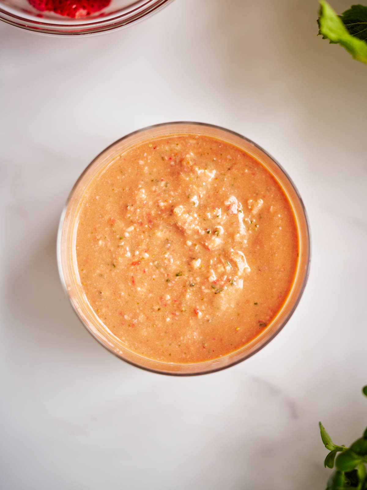 Pink salad dressing in a glass bowl on a countertop.