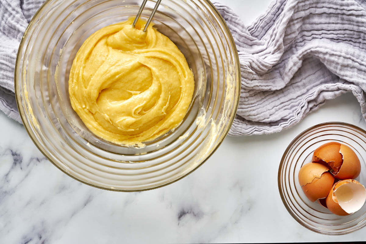 Dough in a glass bowl next to a bowl of egg shells.