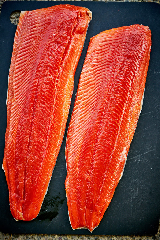 Flatlay of red salmon on a cutting board.