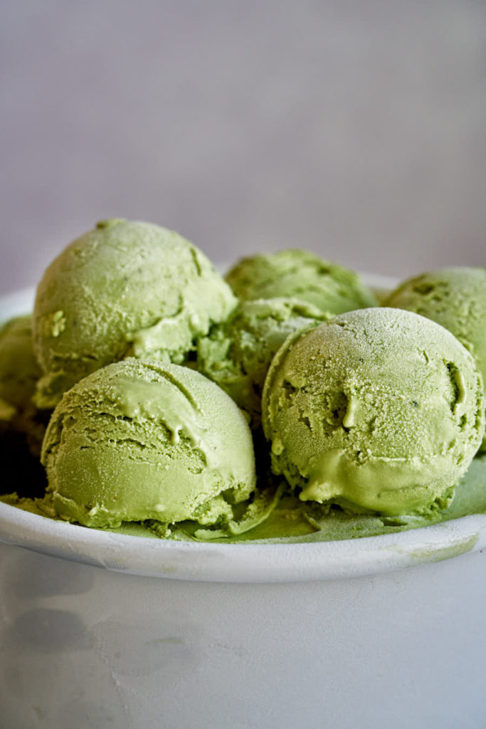 Scoops of green ice cream with grey background.