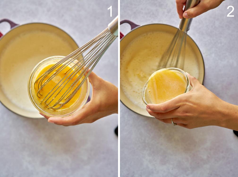 Two hands tempering an egg mixture in a purple pot with whisk.