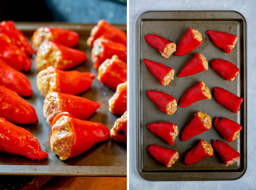 Red stuffed peppers lined up on a baking sheet.