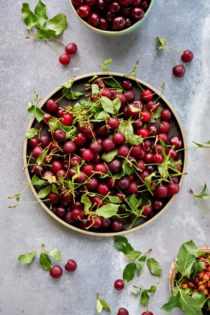 Sour cherries in a black plate on concrete.