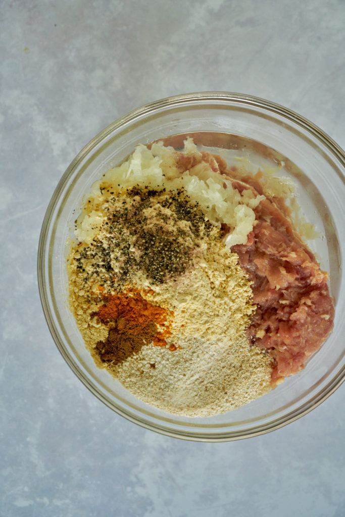 Bowl filled with meatball ingredients.