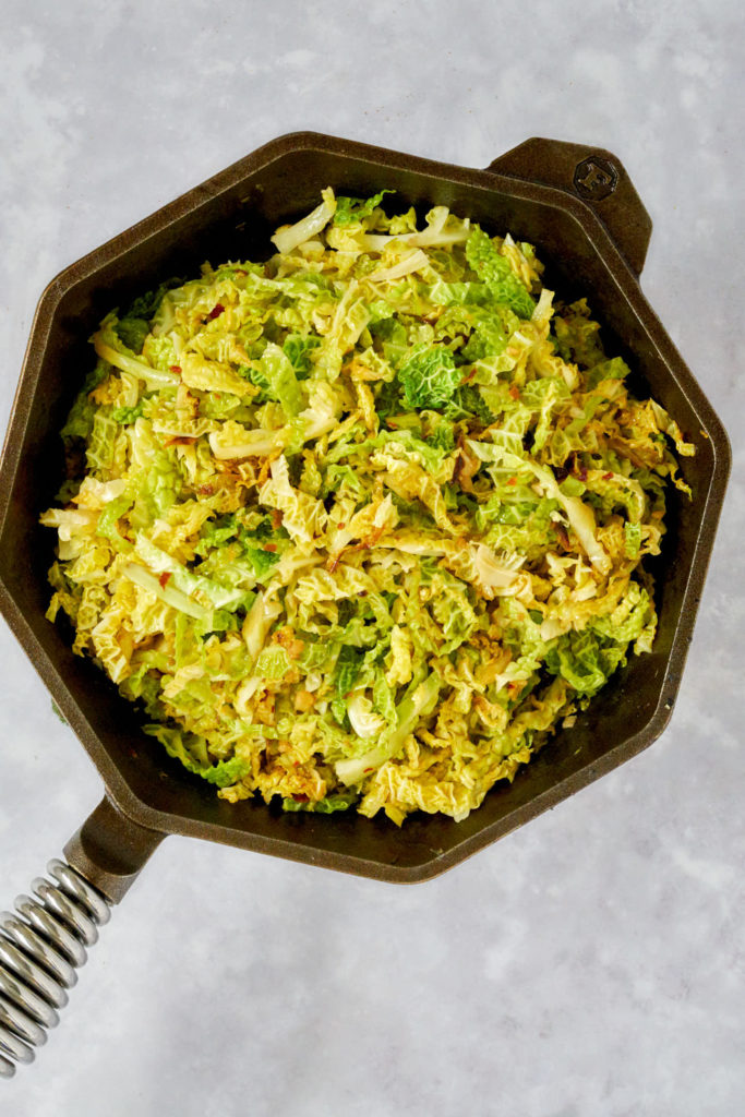 Cooked cabbage in a cast iron pan.