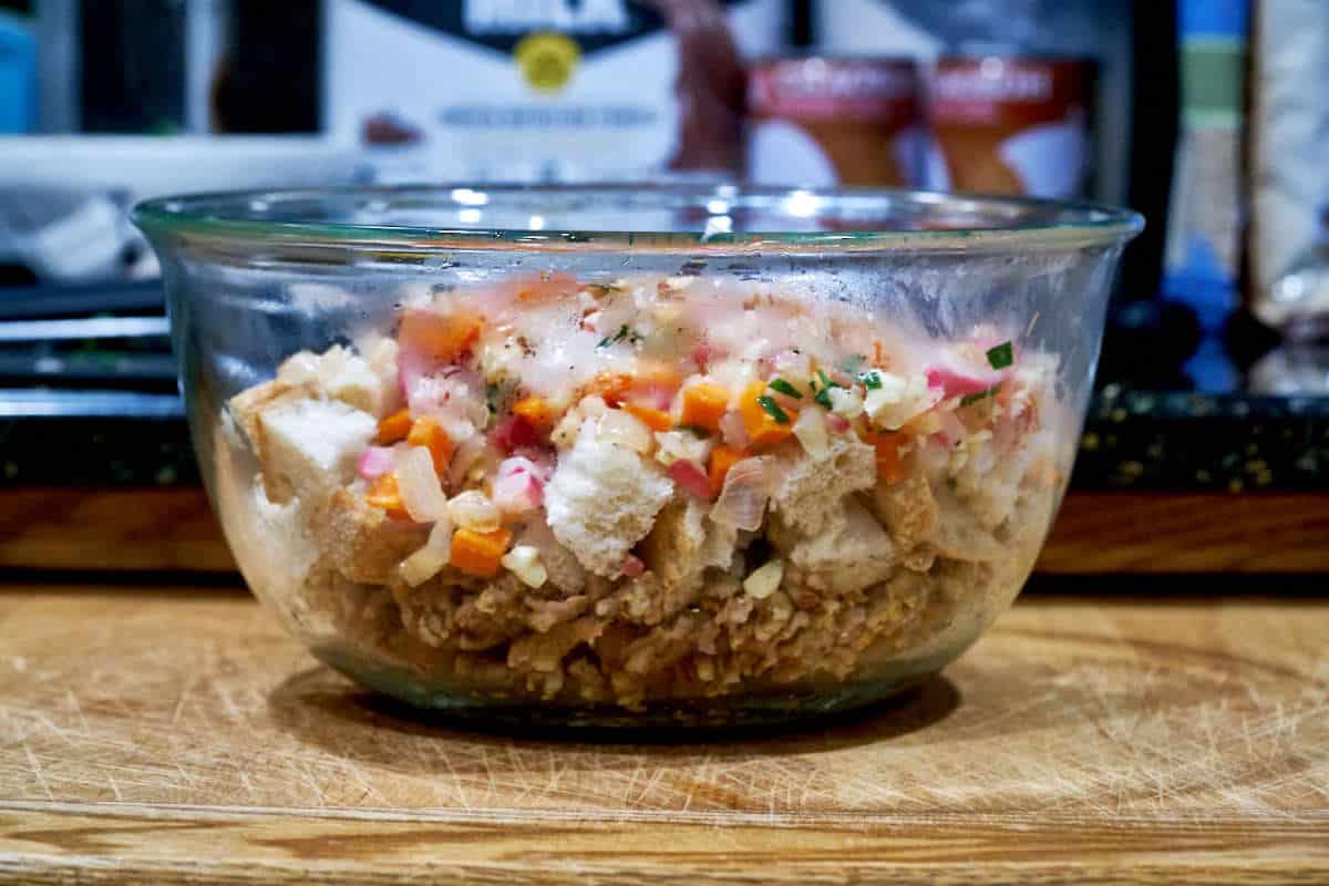 Glass bowl with cooked vegetables and bread.