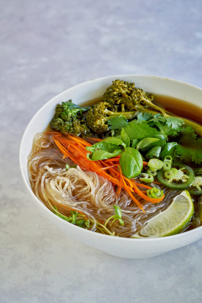 One bowl of noodles soup with vegetables and herbs.