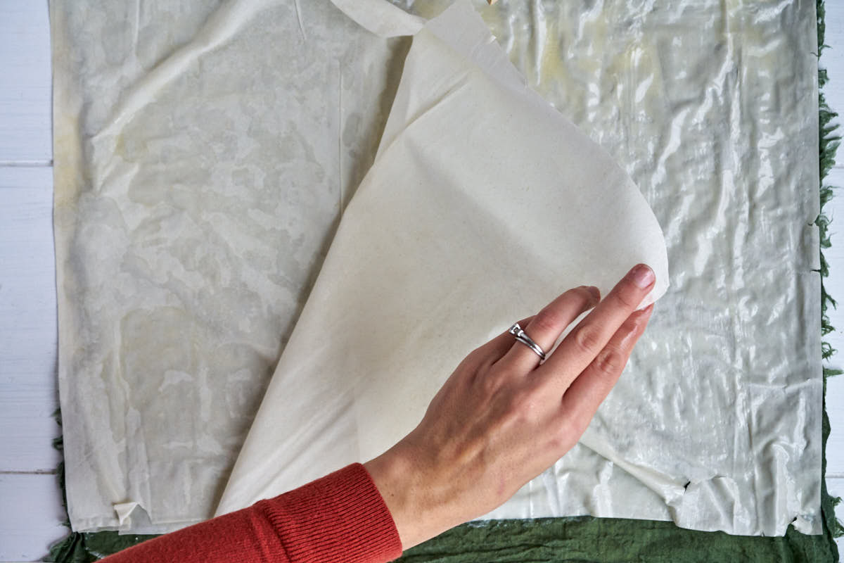 Layering sheets of phyllo dough.