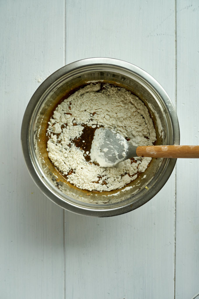 Batter with a spatula in a metal bowl.