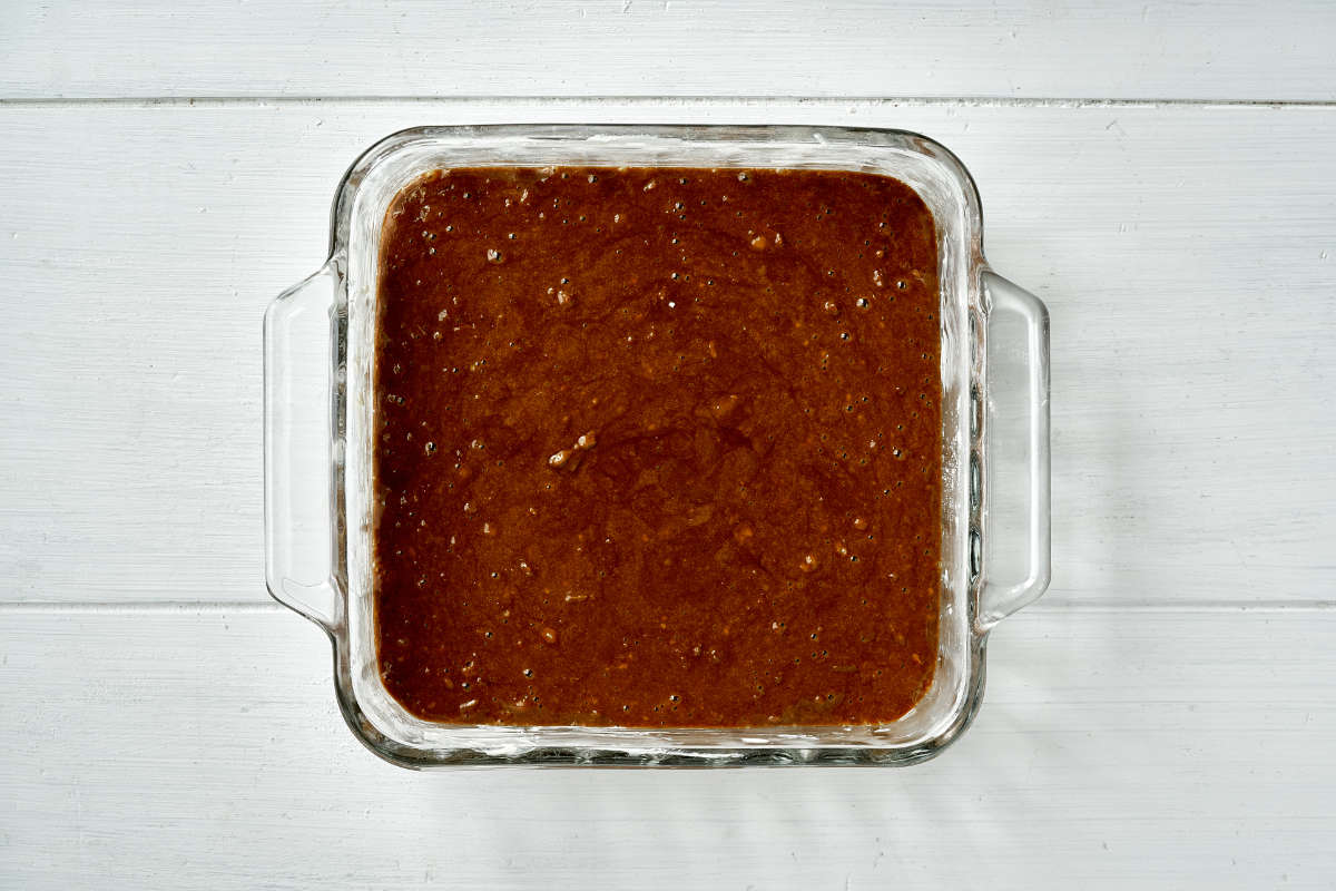 Raw cake batter in a square glass baking dish.