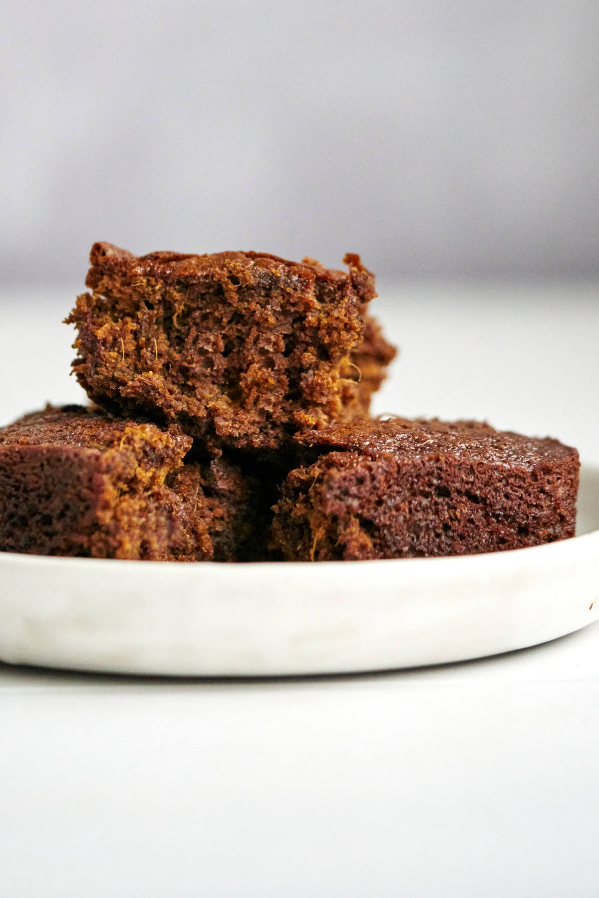 Three squares of cake on a white plate.