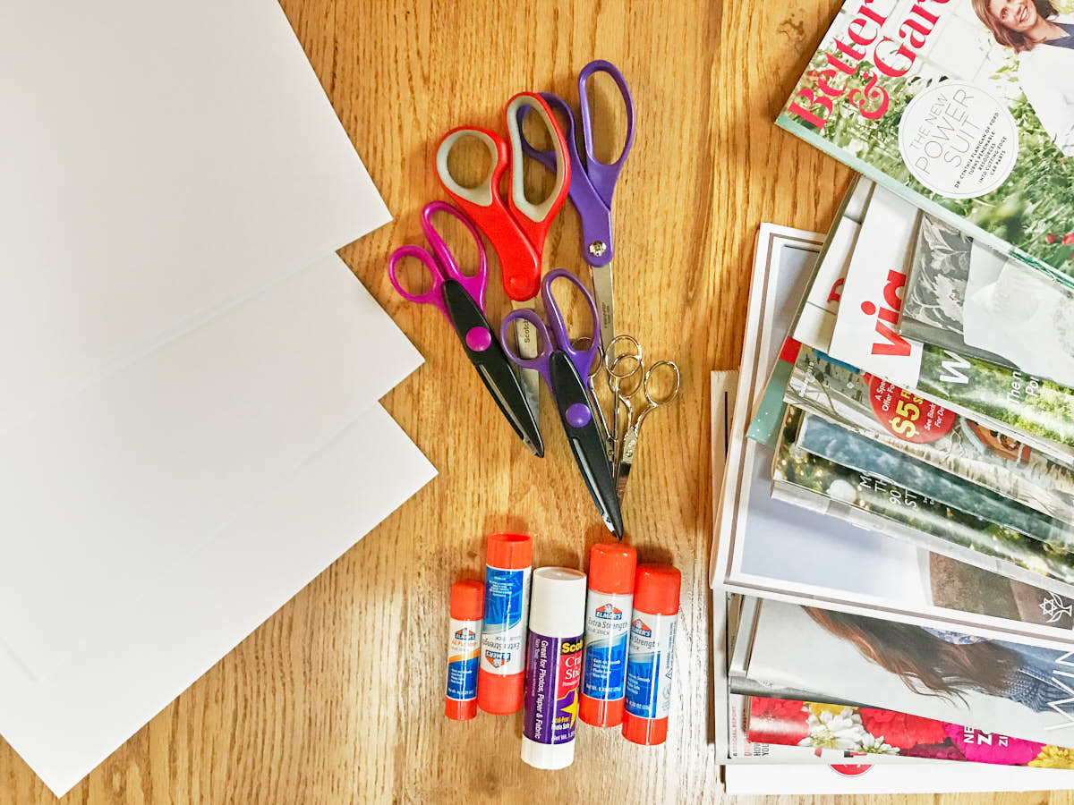 Scissors, glue sticks, paper, and magazines on a hardwood floor.